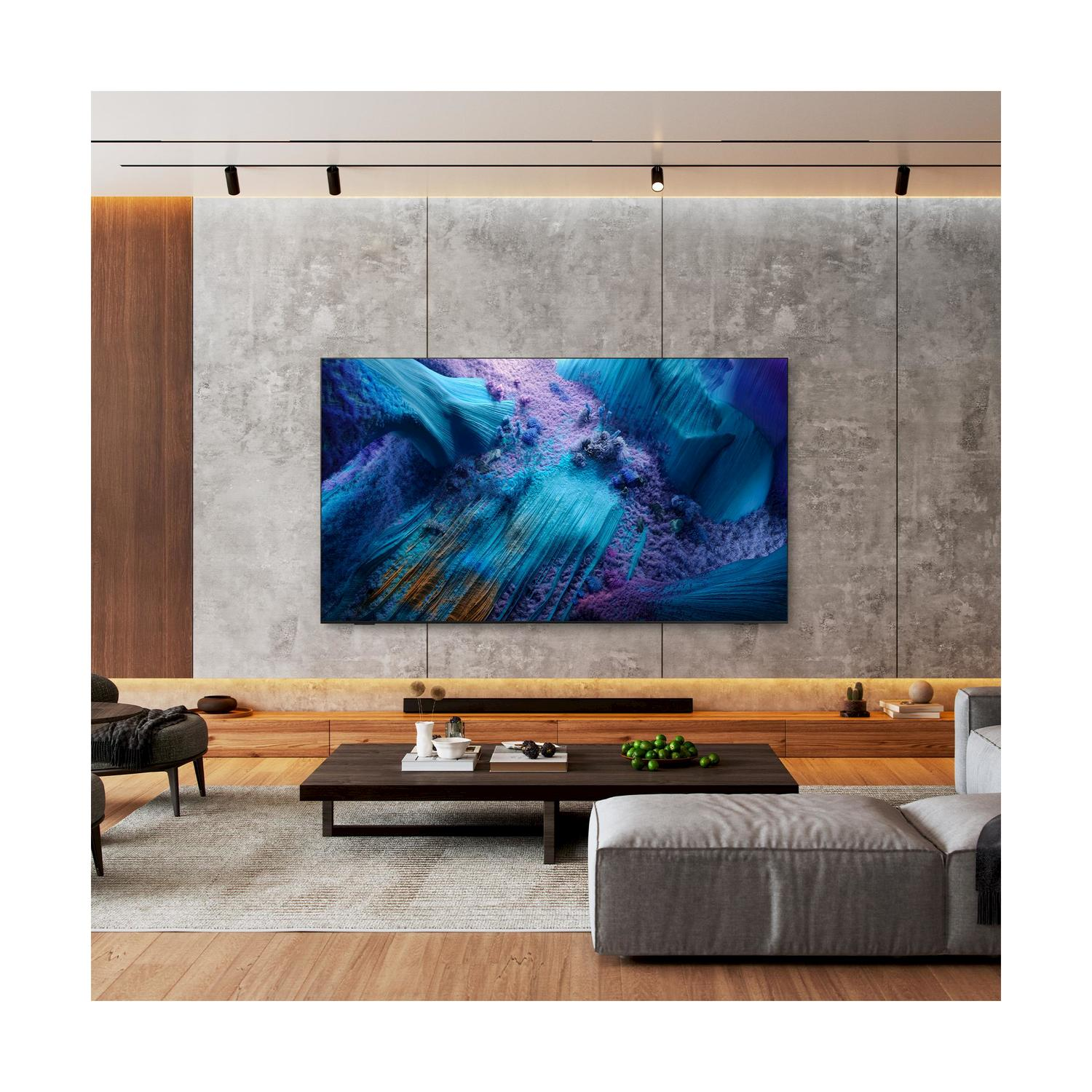 Un moderno soggiorno con un grande televisore che mostra una vibrante opera d'arte astratta. Un divano grigio e un tavolino.
