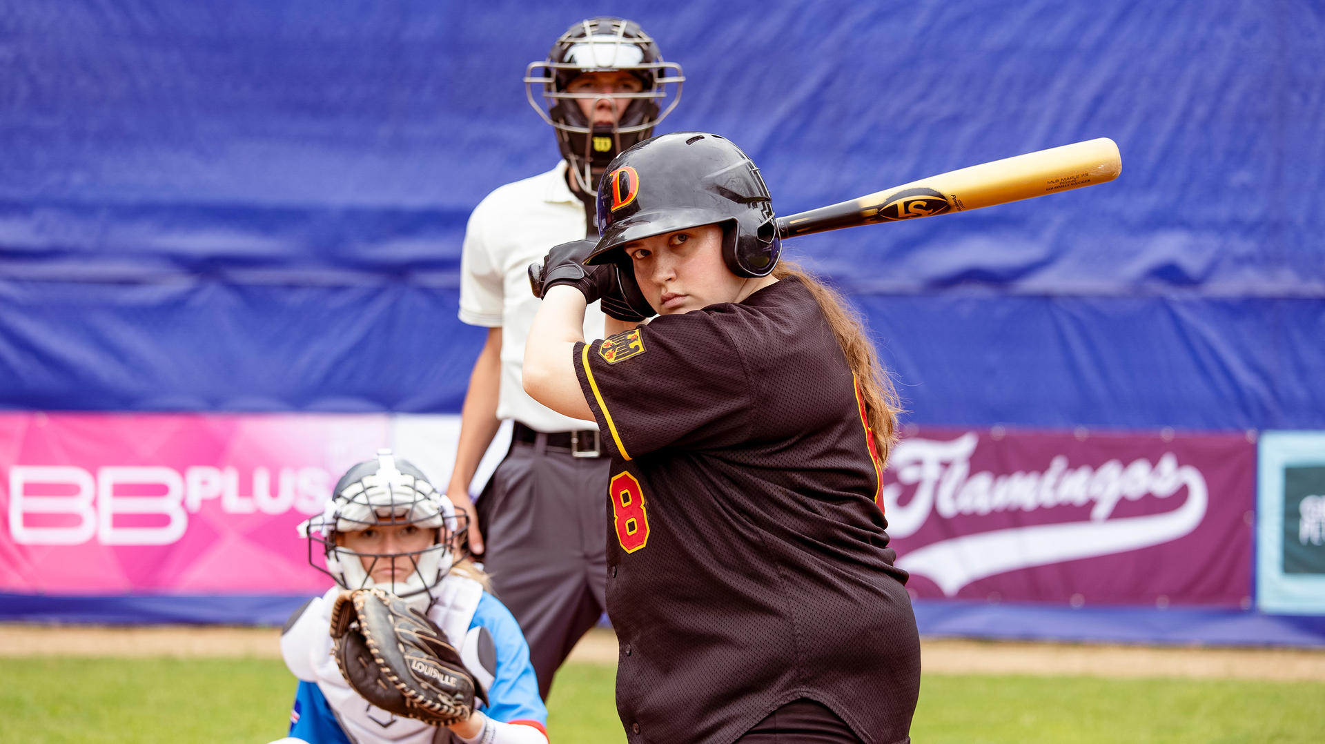 Ein Schlagmann, ein Fänger und ein Schiedsrichter sind auf einem Baseballfeld platziert.