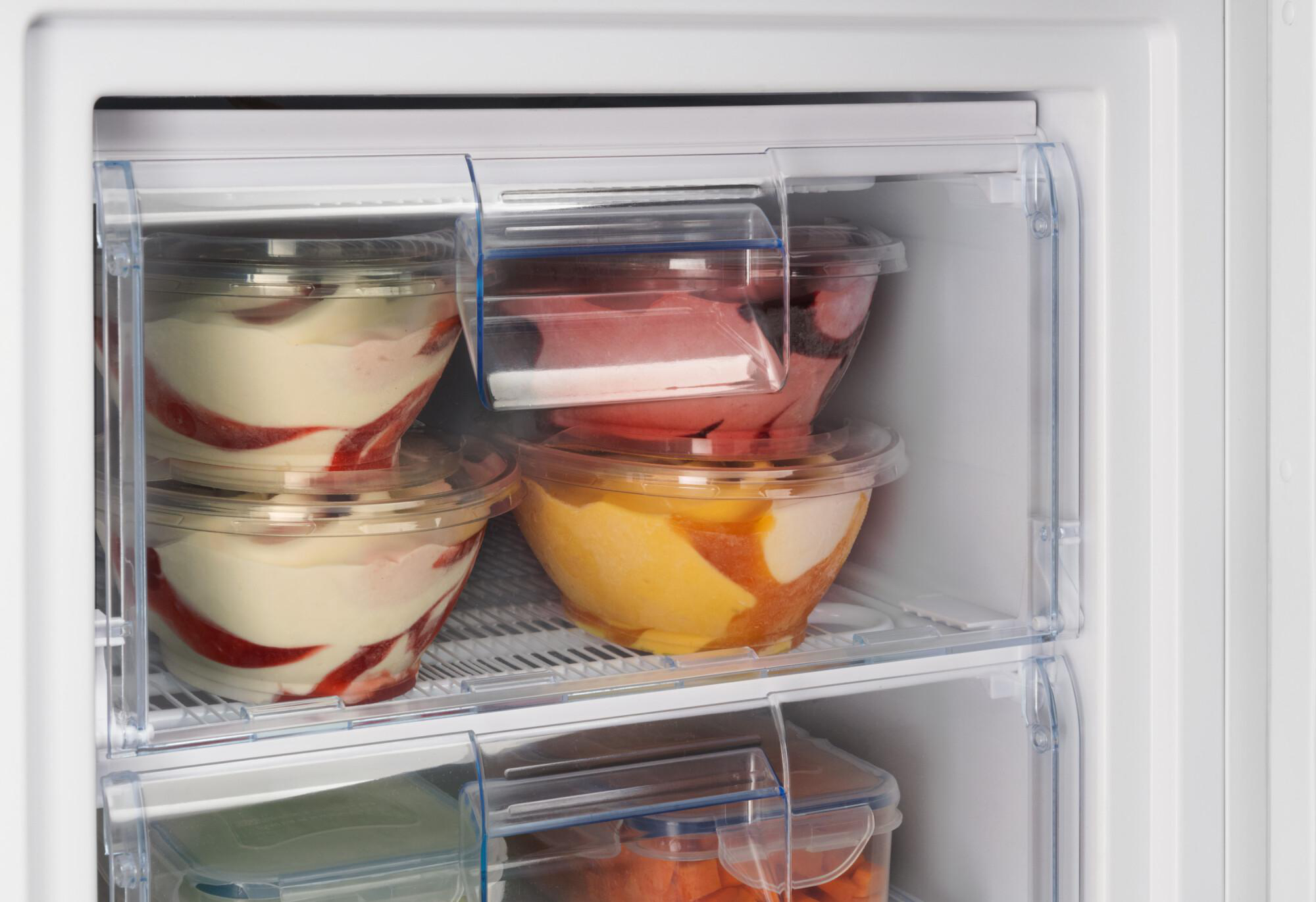 Kühlschrank-Innenraum mit Schalen Essen in Schubladen. Erdbeeren sichtbar.