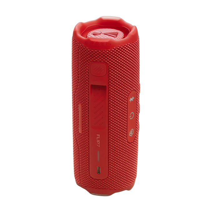 Altavoz cilíndrico rojo con botones y puertos. Marca: JBL Flip 7. Fondo negro.