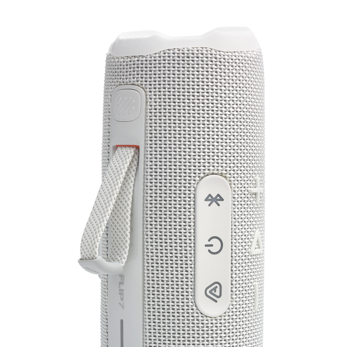 Altavoz JBL Flip 7 blanco. Primer plano de botones, lazo y asa. Fondo oscuro.
