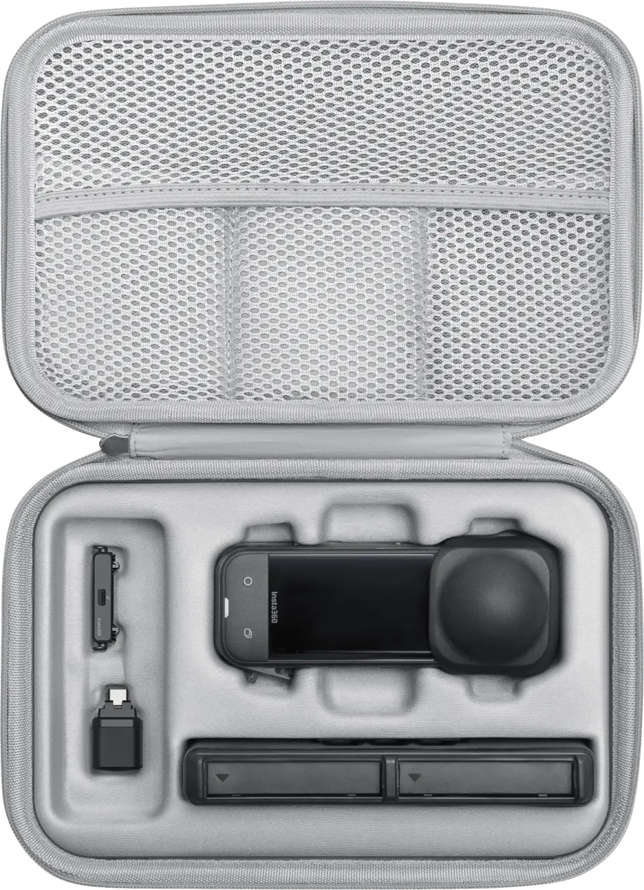 Geöffnete graue Tasche mit Kamera, Batterieladegerät und anderem Zubehör auf weißer Oberfläche.