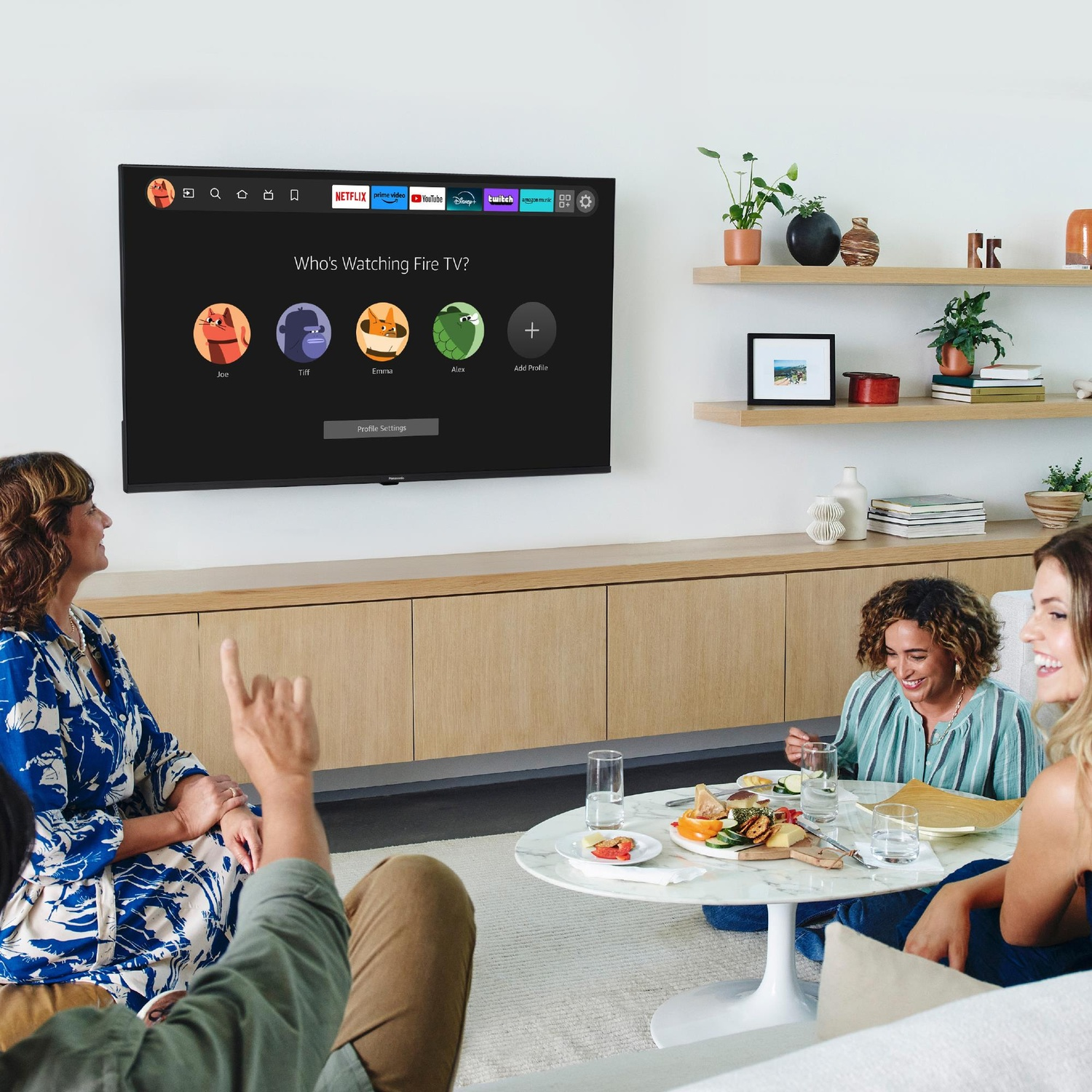 Un gruppo di persone guarda uno schermo TV con profili di app di streaming.