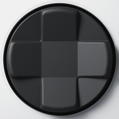 Ein schwarzes rundes Panel mit quadratischen Feldern, die in einem Rastermuster angeordnet sind. Die Quadrate sind texturiert.
