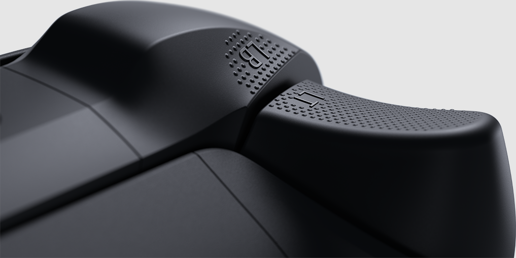 Primo piano di un controller di gioco nero. Il pulsante LB è visibile, la superficie ha un motivo strutturato.