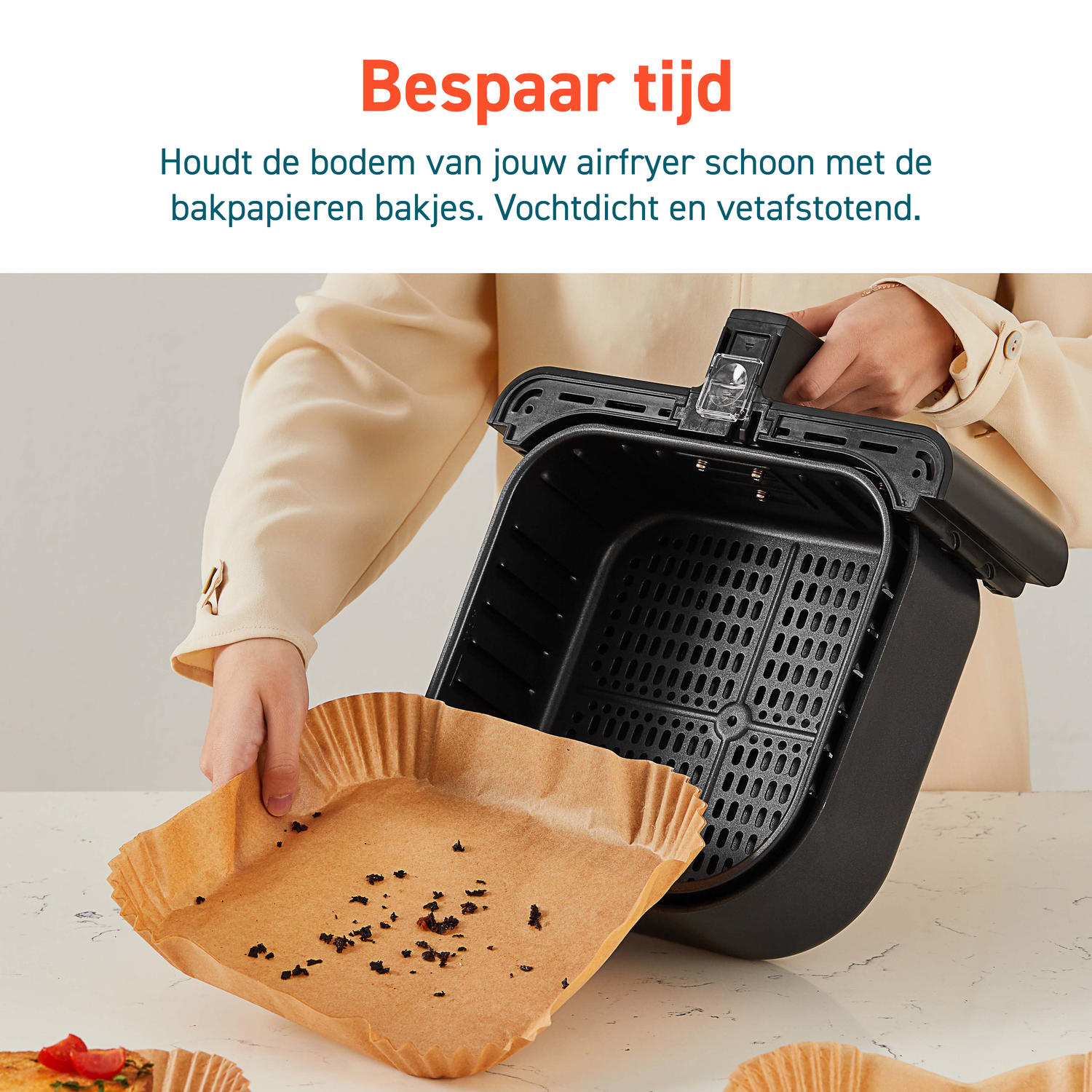 Person holding a paper liner for an air fryer. The liner is in the air fryer basket.