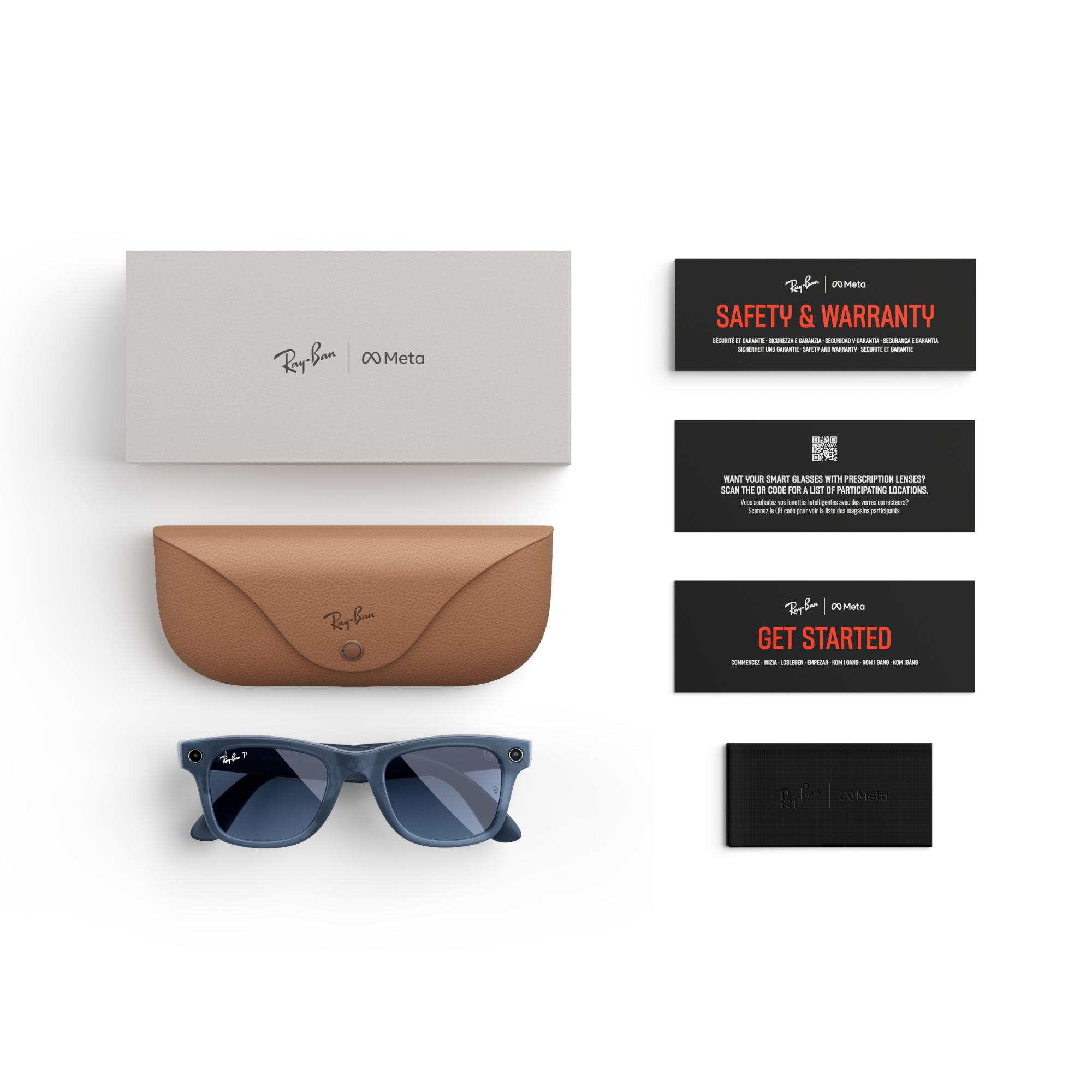 Graue Box, hellbraunes Etui, blaue Sonnenbrille und Karten. Marke Ray-Ban und Meta sind sichtbar.