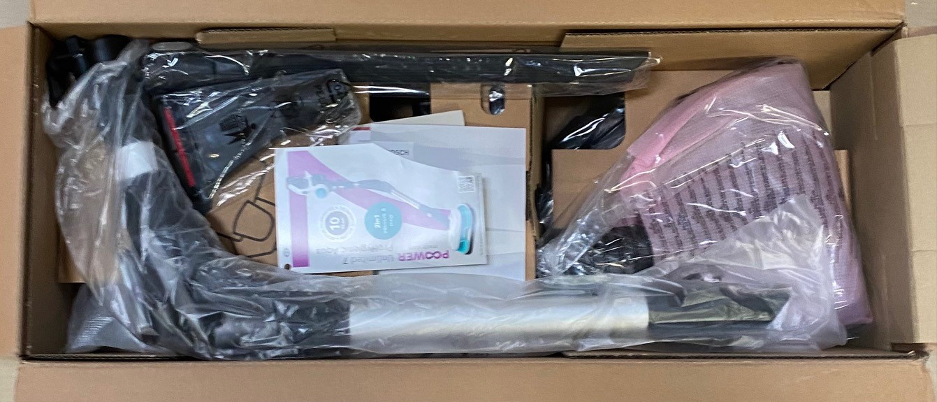 Otwarty karton z częściami odkurzacza zapakowanymi w plastikowe opakowanie.