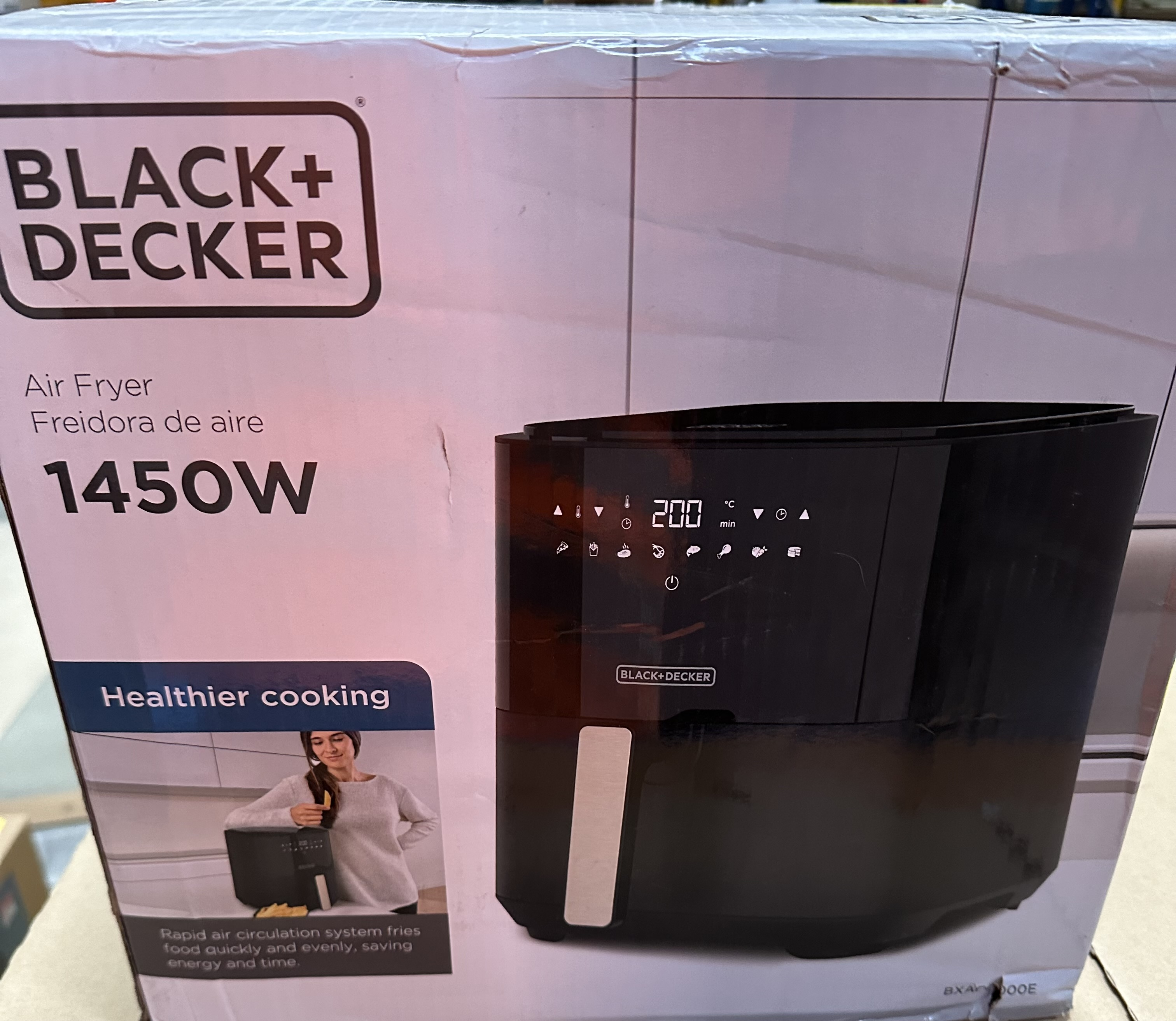 Frytownica beztłuszczowa Black+Decker na pudełku, z kobietą w rogu. Wyświetla ustawienia i informacje o gotowaniu.