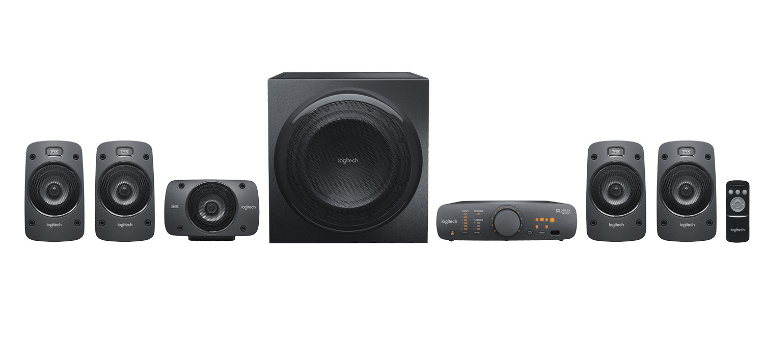 Zestaw głośników stereo, sub i pilot, wszystko czarne, białe tło.