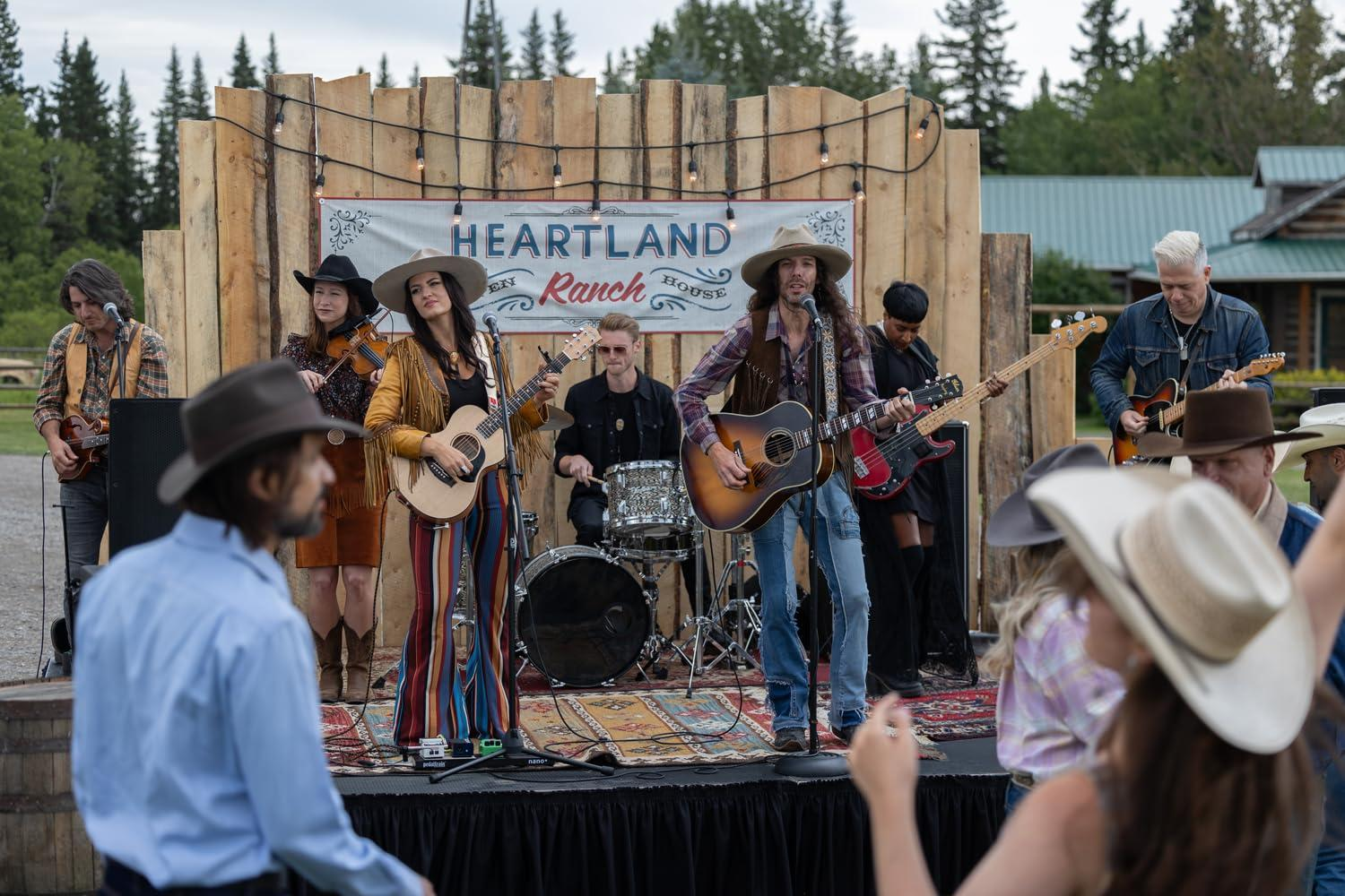 Eine Band spielt auf einer Freilichtbühne auf der Heartland Ranch. Leute tanzen vor der Bühne.
