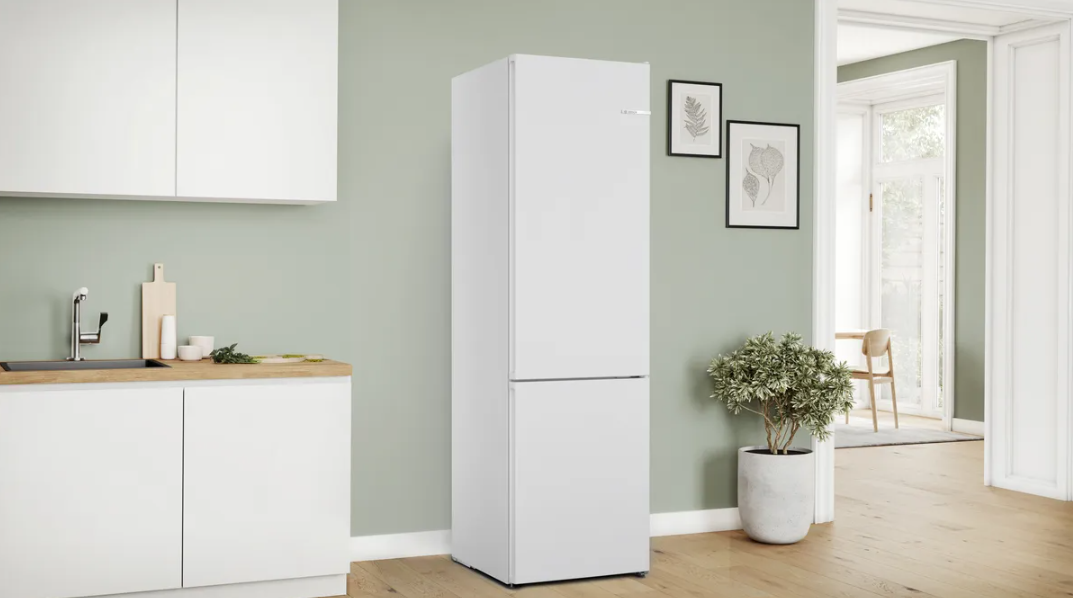 Refrigerador blanco en un ambiente de cocina moderno, con pared verde claro.