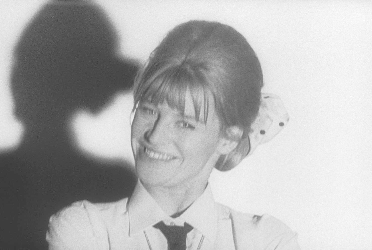 Lächelnde Frau mit Dutt, Schatten an der Wand.