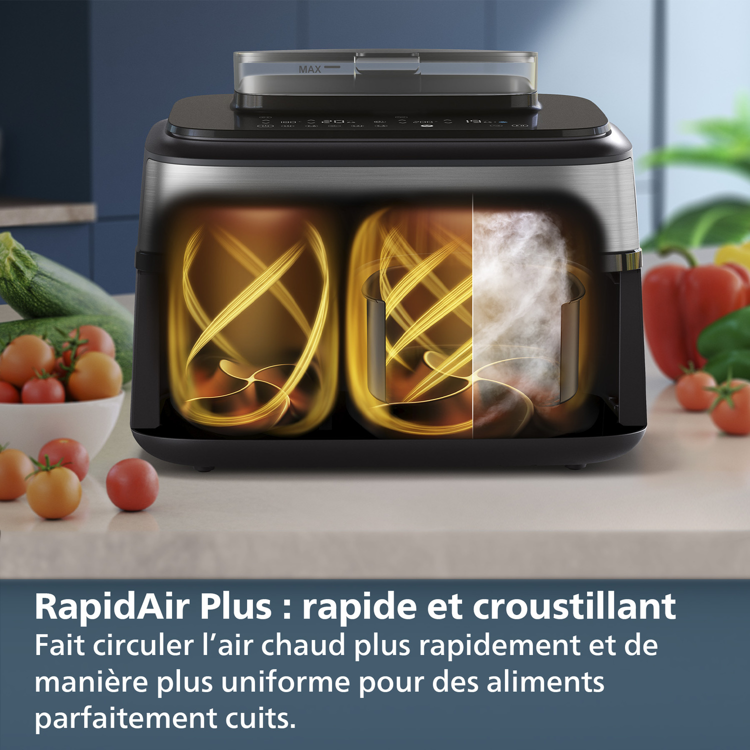Friteuse à air noire avec deux compartiments. Tomates et courgettes au premier plan sur surface blanche.