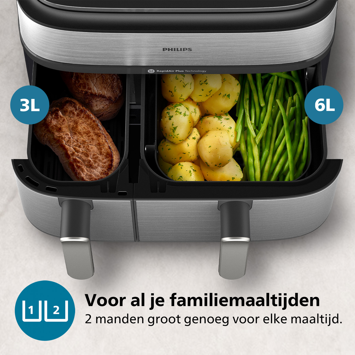Een Philips Airfryer met twee compartimenten, een met steak en de andere met aardappelen en bonen.
