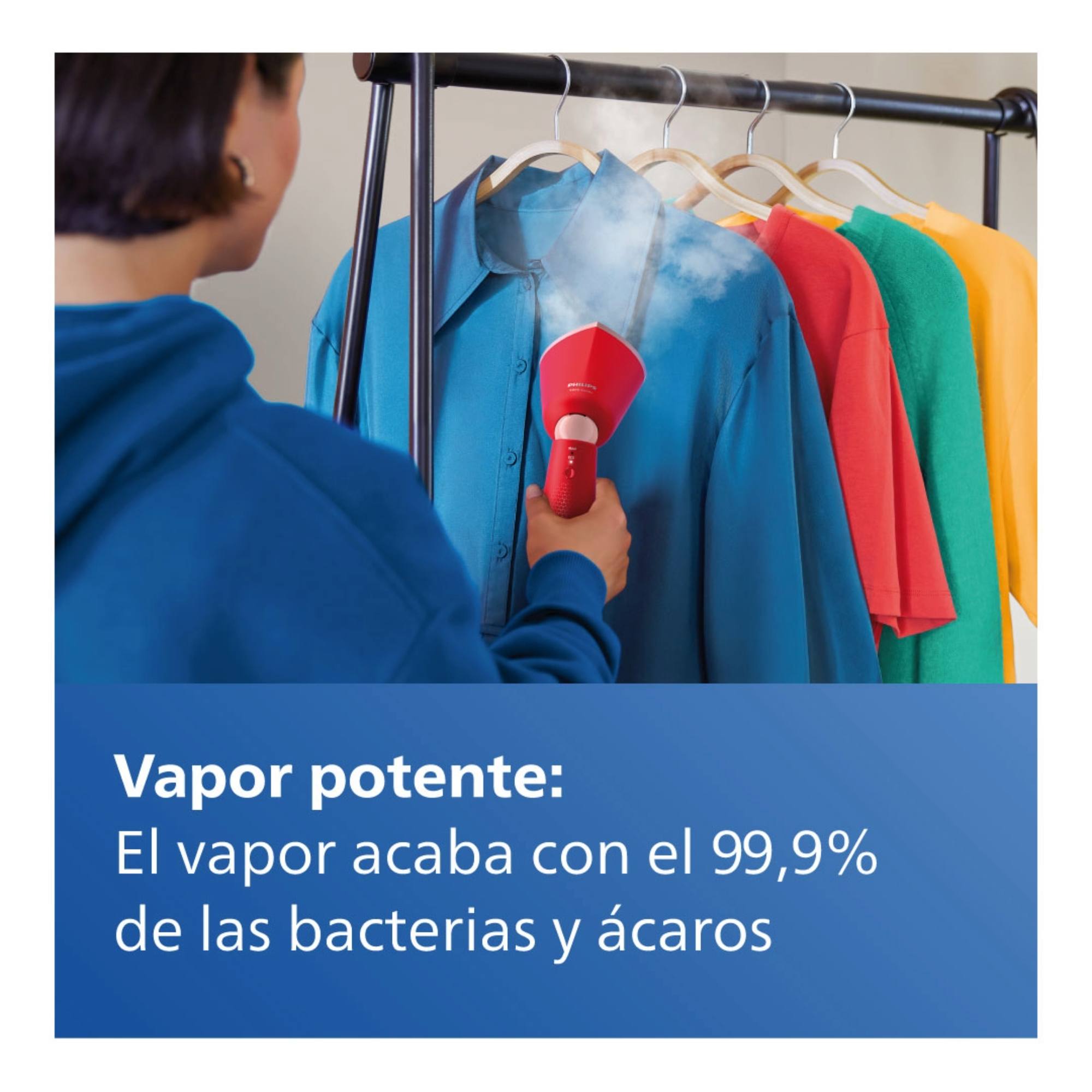 Mujer planchando ropa con vaporizador rojo. Camisas azul, roja, verde y amarilla en perchero.
