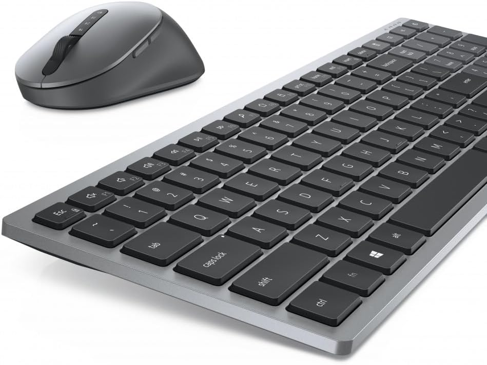 Conjunto de teclado y ratón. El teclado es plateado con teclas negras. El ratón es gris y tiene una rueda de desplazamiento.