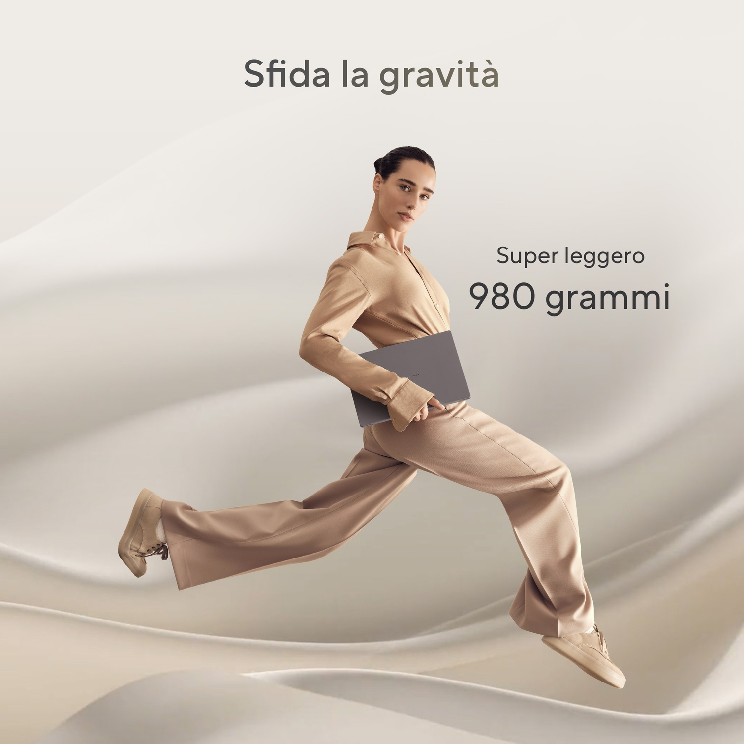 Una donna salta, tenendo un laptop. Testo: Sfida la gravità, Super leggero 980 grammi.