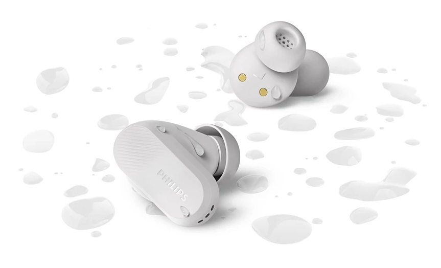 Dwie białe słuchawki leżą na powierzchni z kroplami wody. Nazwa marki Philips jest na jednej z nich.