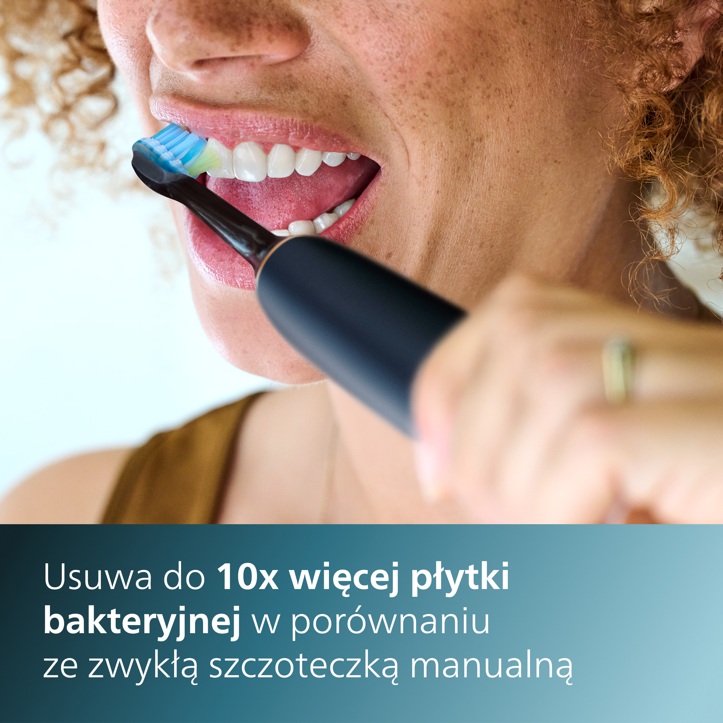 Osoba myje zęby szczoteczką elektryczną.
