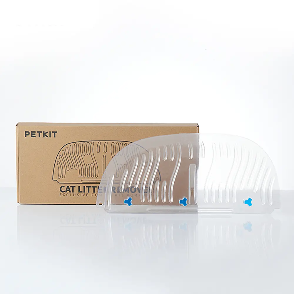 Katzenstreumatte und Box. Die Matte ist aus klarem Kunststoff mit blauen Akzenten. Die Box ist Pappe.
