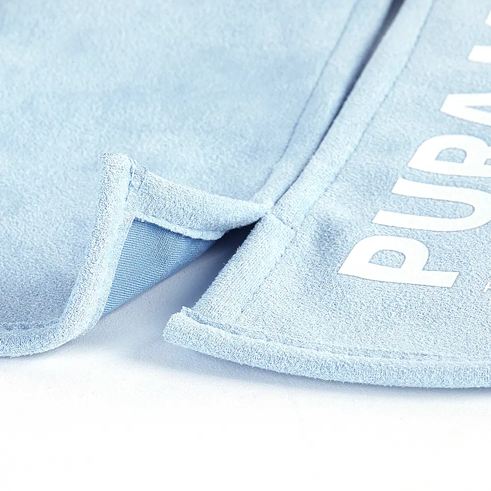 Détail de tissu bleu clair avec un bord découpé et le mot 'PURPLE'.