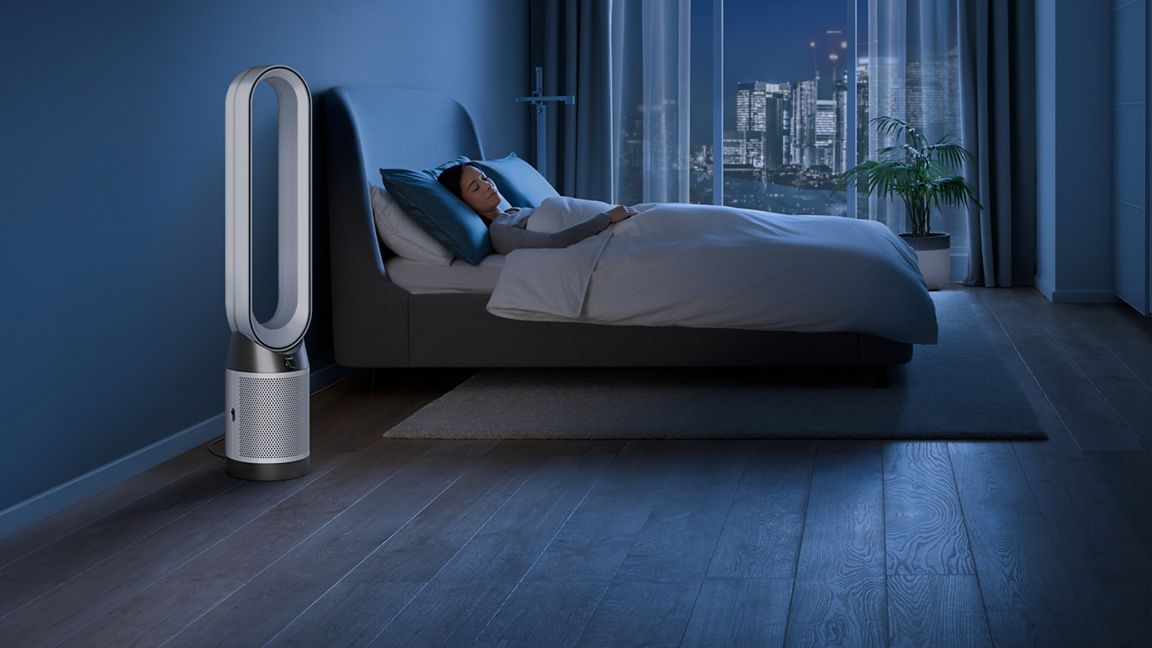 Purificateur d'air dans la chambre la nuit. Femme dormant dans son lit.