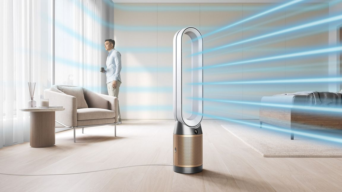 Un purificateur d'air moderne soufflant de l'air vers un homme debout près d'une fenêtre dans une pièce.