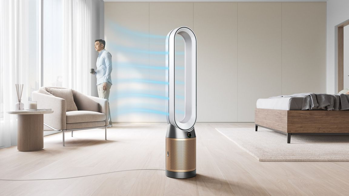 Un ventilateur moderne avec un homme debout près d'une fenêtre, avec un lit et un fauteuil.