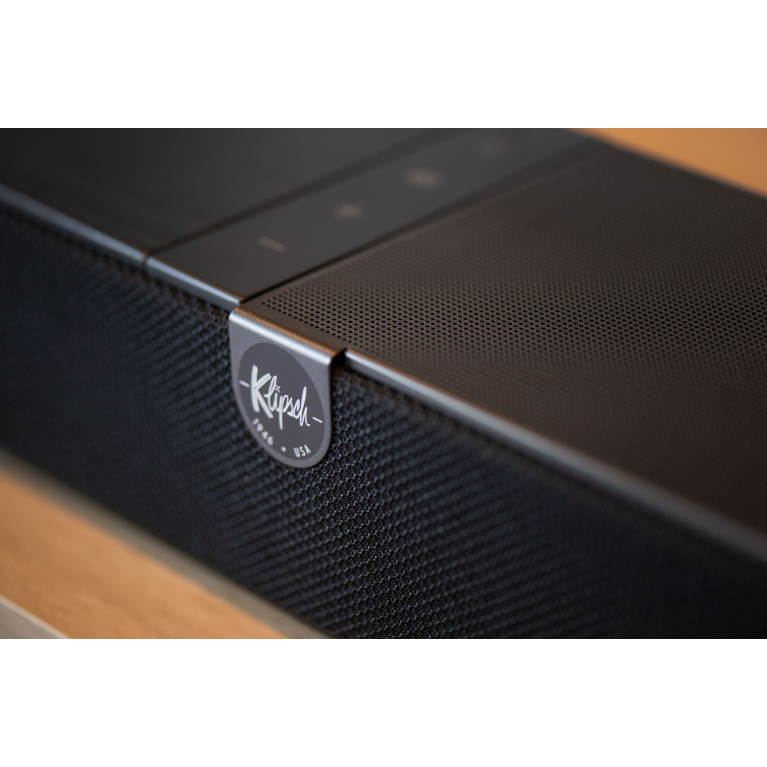 Close-up van een zwarte soundbar met mesh voorkant en Klipsch logo.
