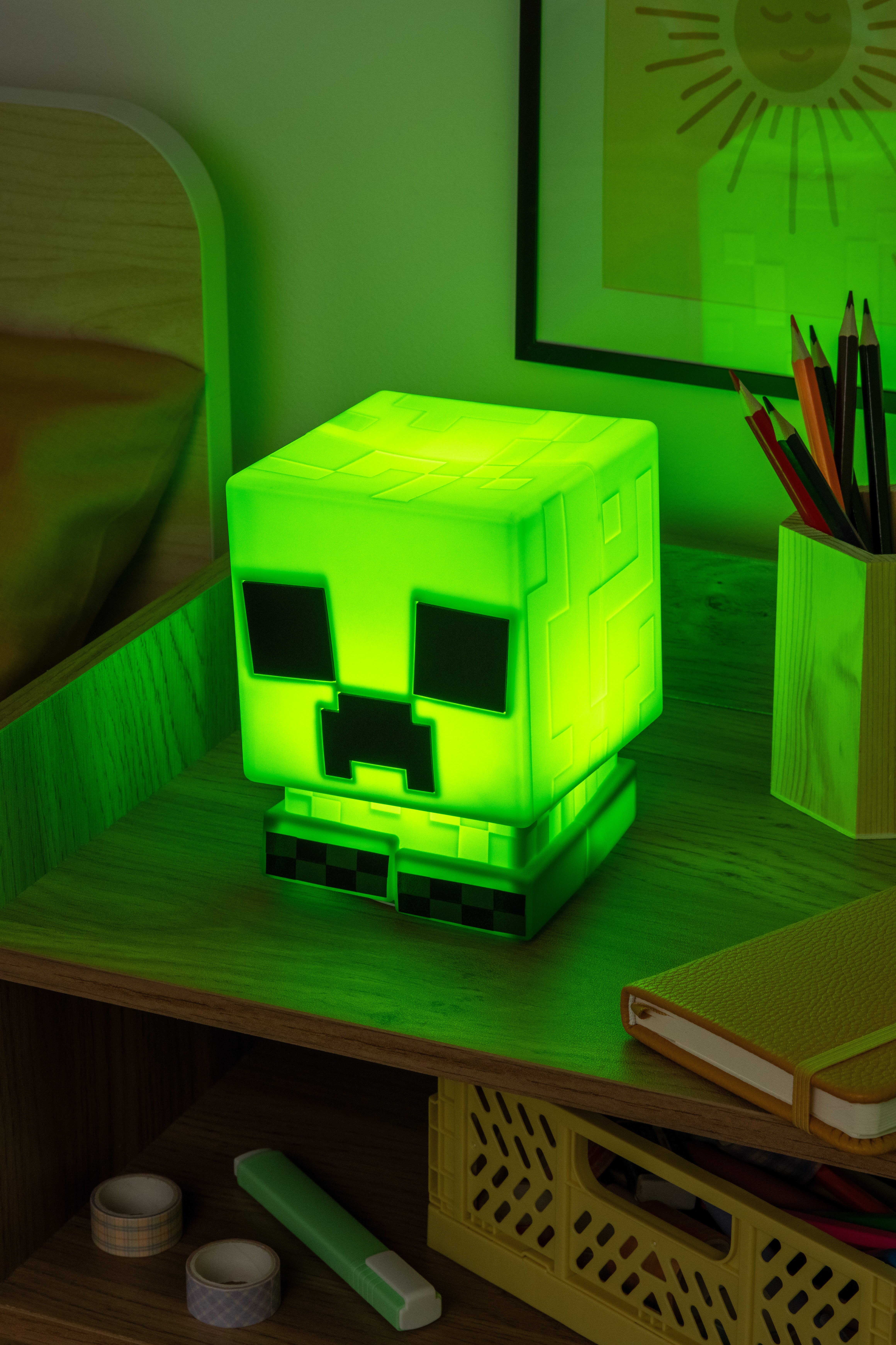 Eine grüne Minecraft Creeper Lampe. Sie steht auf einem grünen Tisch in einem Raum.