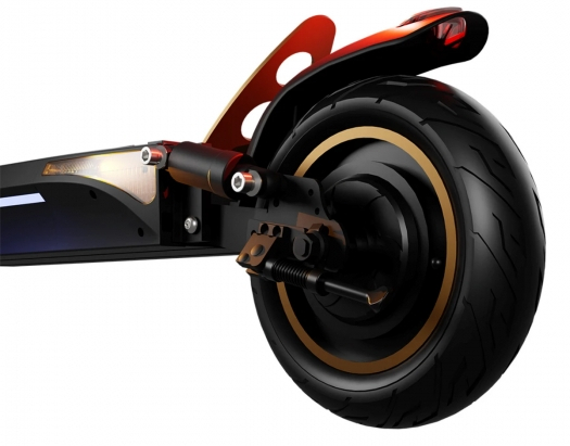 Zbliżenie tylnego koła czarno-złotej hulajnogi elektrycznej. Białe tło.