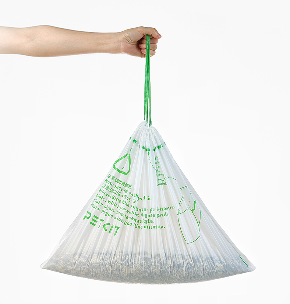 Person hält weißen Plastik-Tierabfallbeutel. Grüner Schnurverschluss, gefüllt mit Abfall.