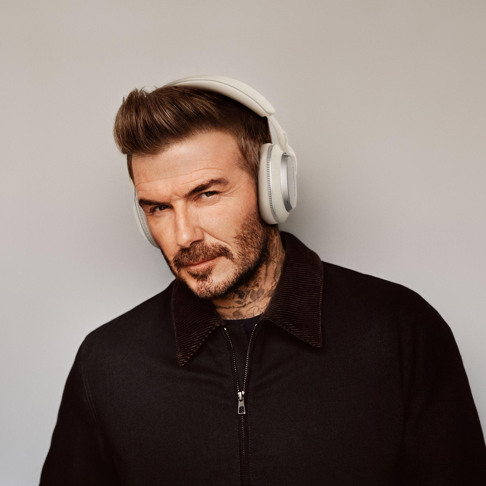 David Beckham trägt weiße Kopfhörer, blickt in die Kamera.