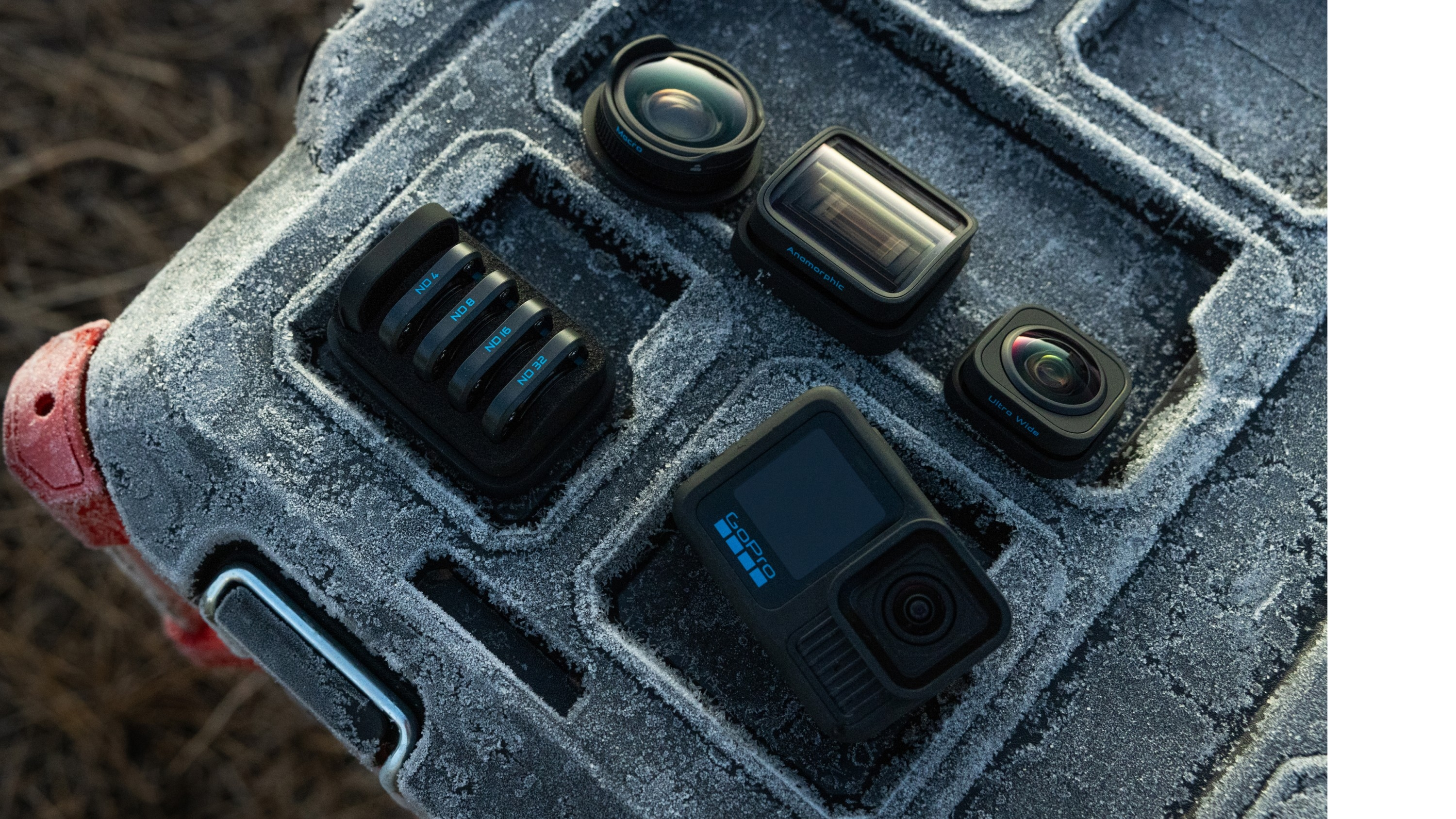 GoPro-Kamera mit verschiedenen Objektiven und Filtern. Auf einer strukturierten Oberfläche platziert, im Freien.