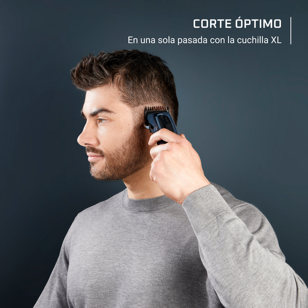 Hombre afeitándose la cabeza con recortadora. Mira a la izquierda. Texto: 'Corte óptimo con cuchilla XL'.