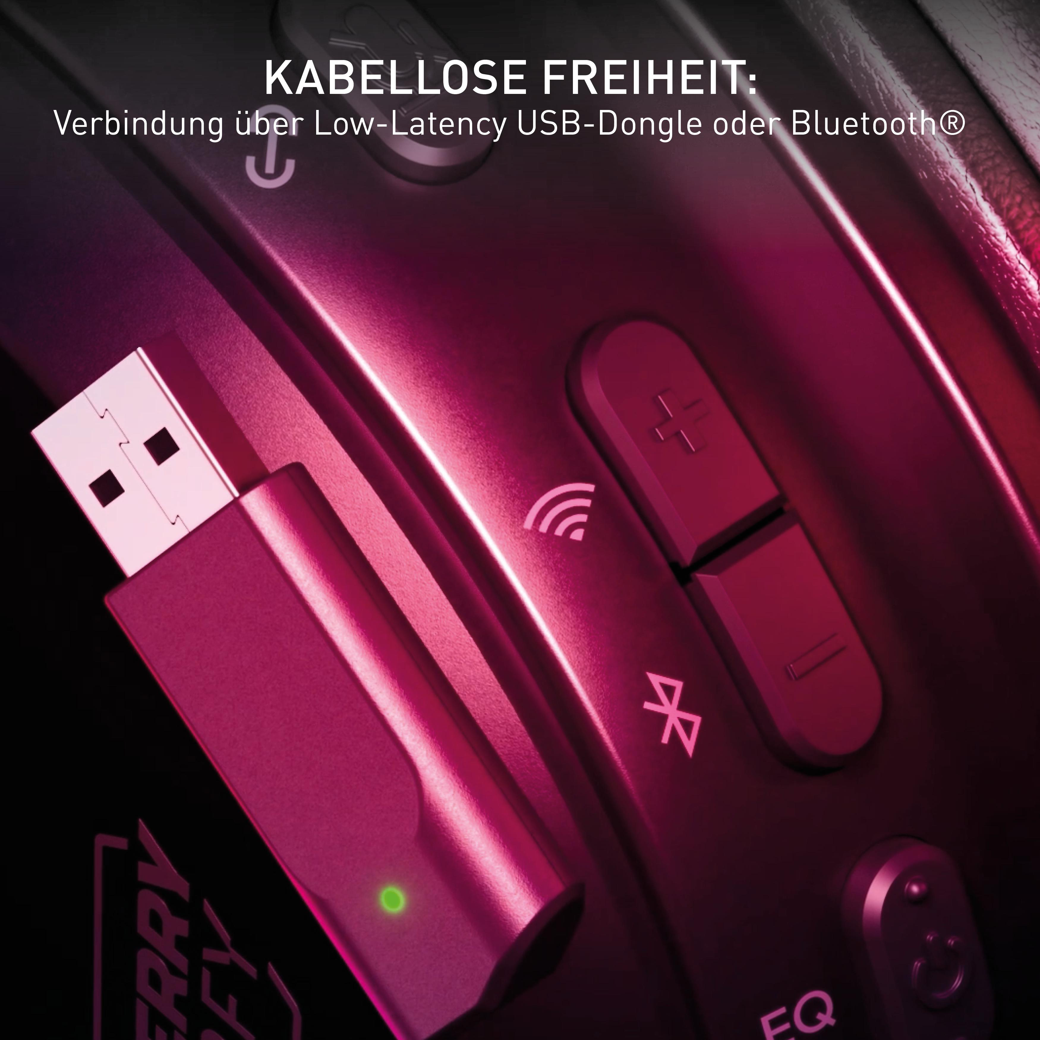 Nahaufnahme eines pinkfarbenen USB-Dongles und Knöpfen, mit dunklem Hintergrund.