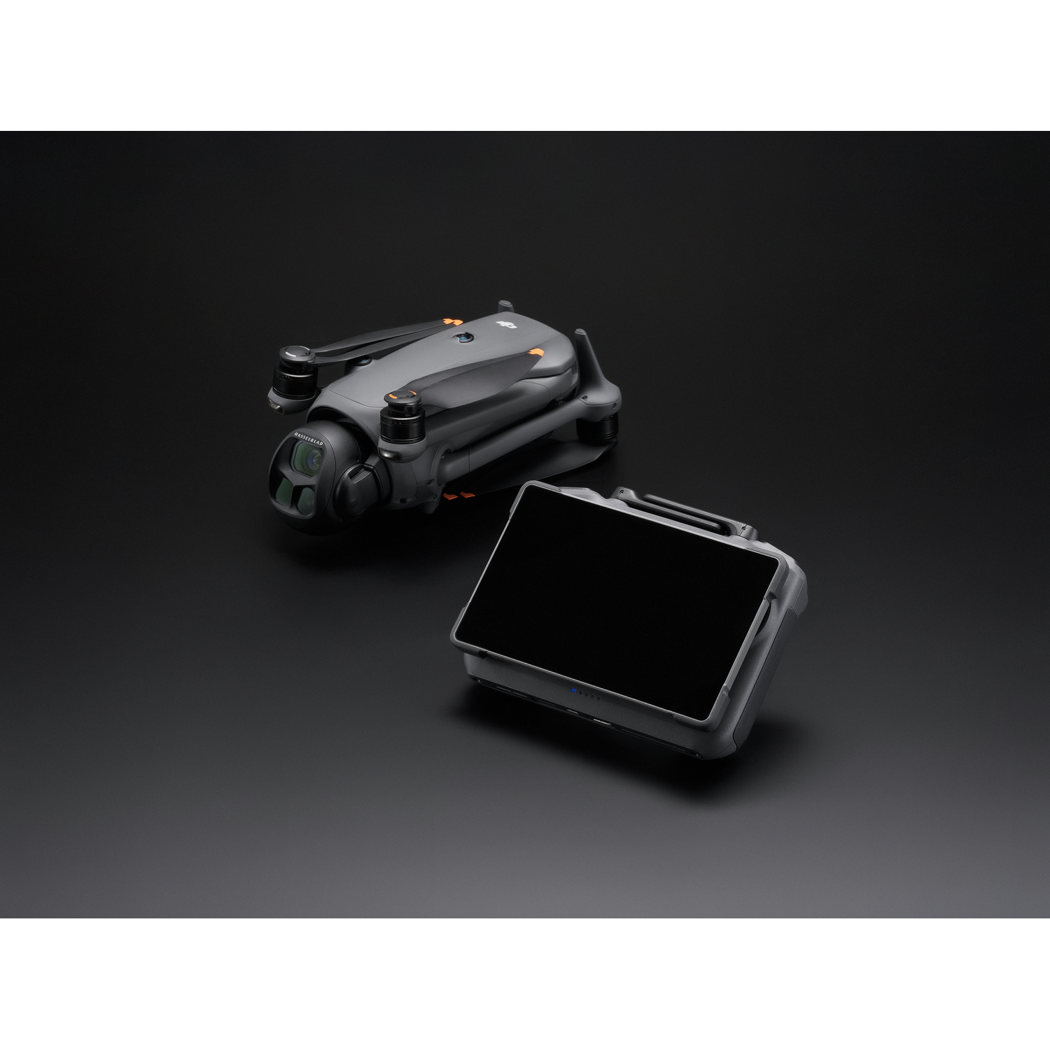 Drone and controller on a black surface.