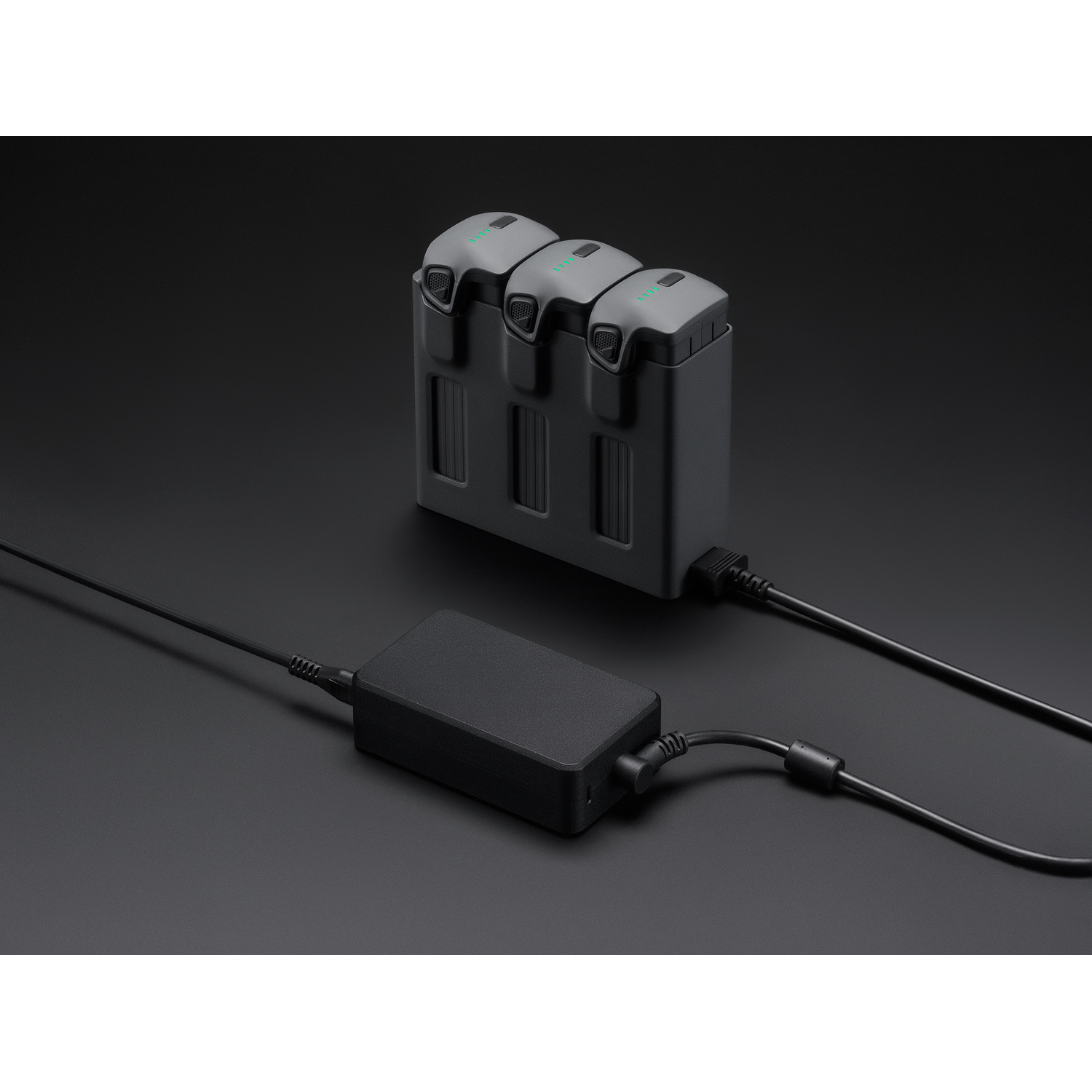 A charging station with batteries and a power adapter, on a black background.