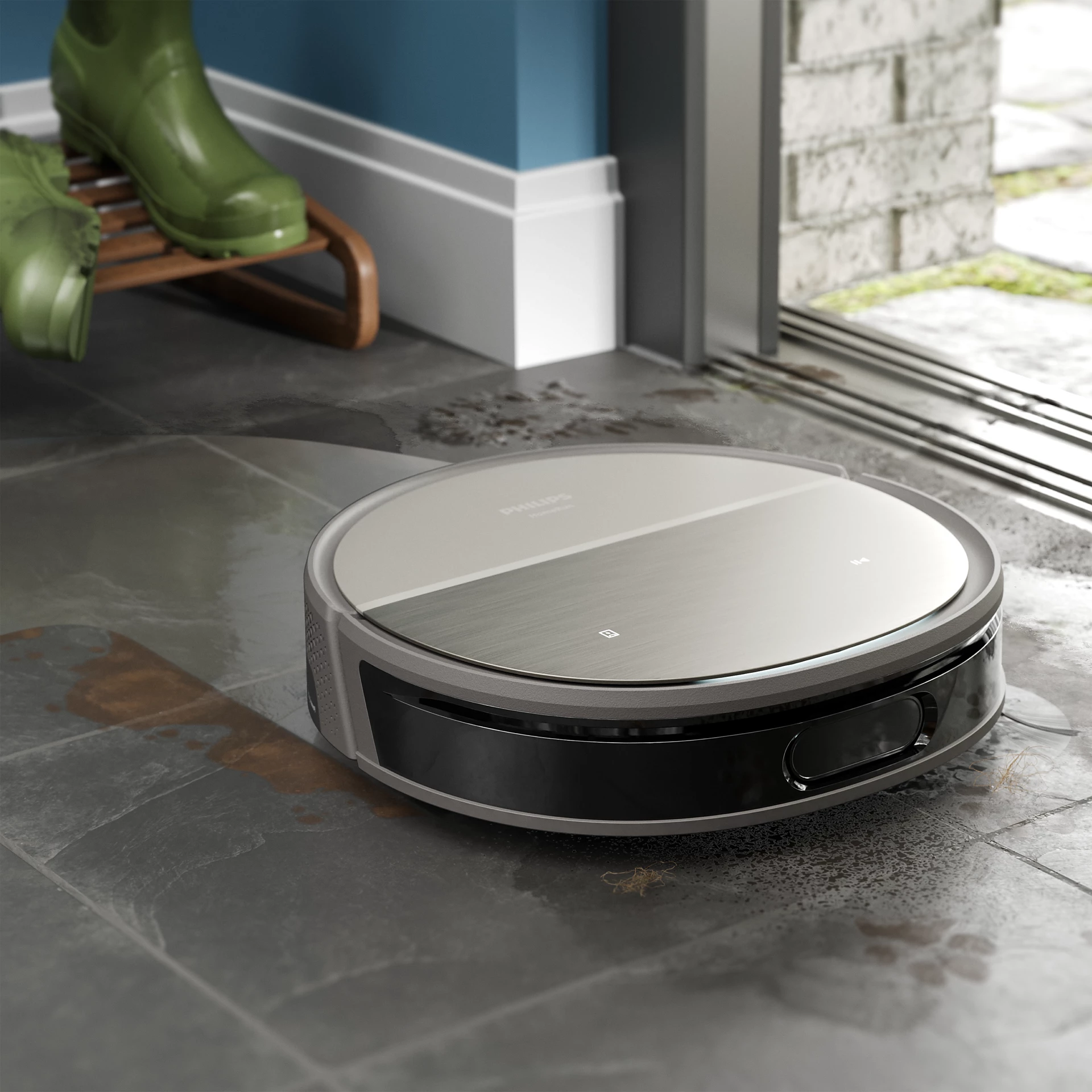 Robot porszívó csempézett padlón. Zöld csizmák és egy fa cipőtartó a háttérben.