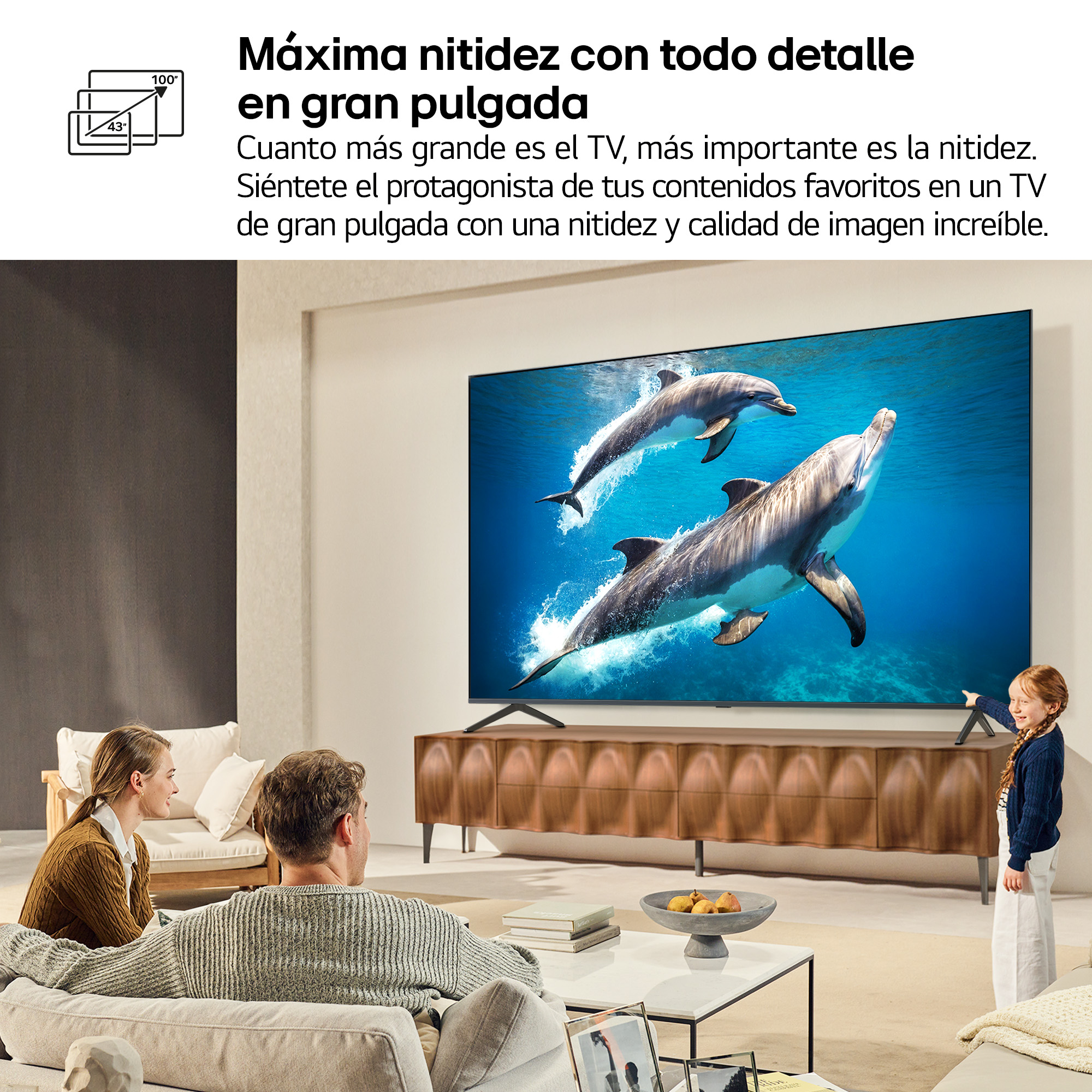 Sala de estar con TV grande mostrando delfines; familia mirando.