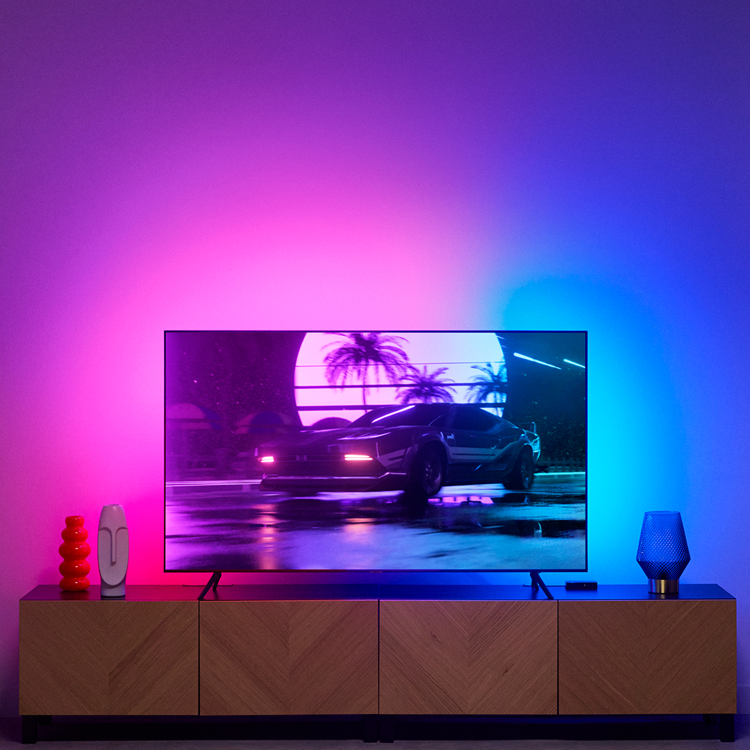 Ein Fernseher auf einem Holzschrank mit Umgebungsbeleuchtung im Hintergrund.