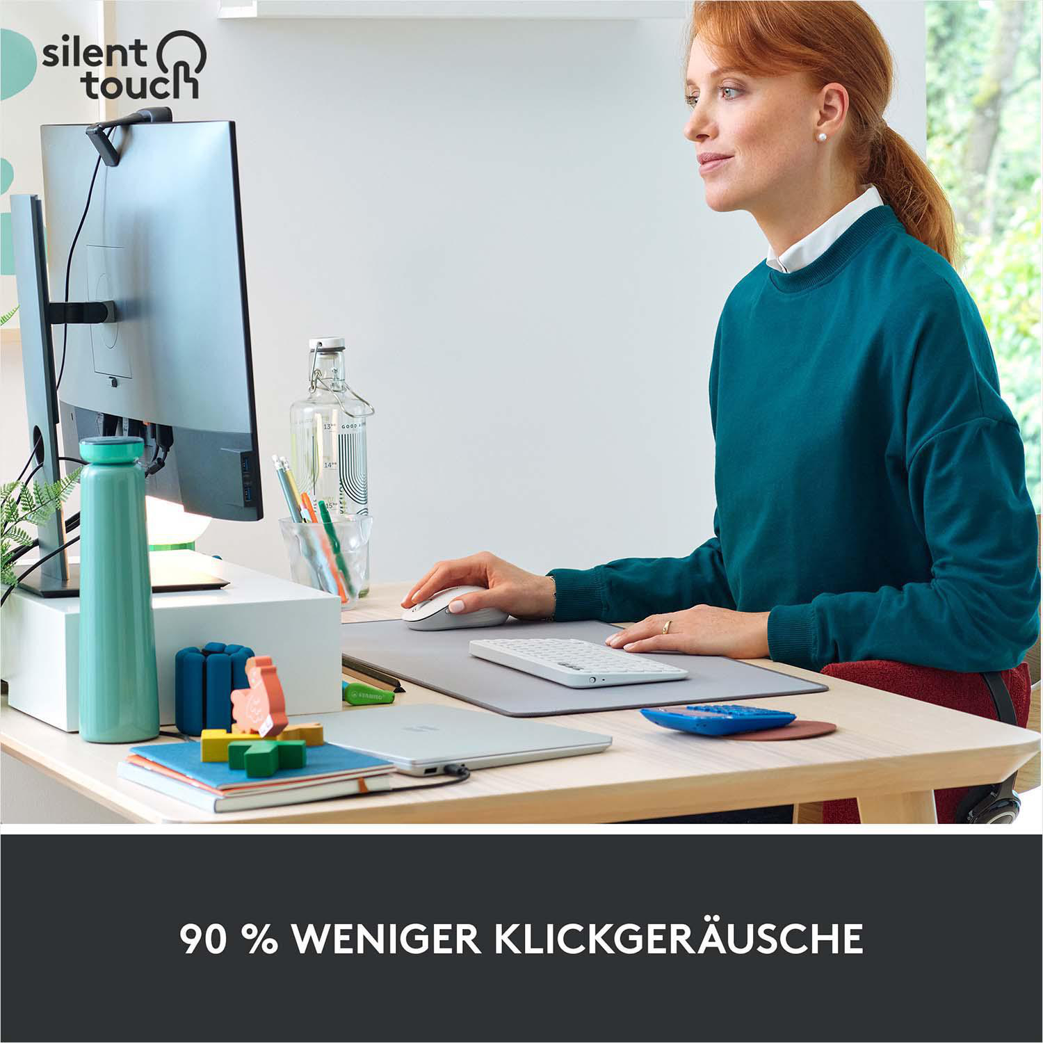 Frau arbeitet am Schreibtisch; Maus, Tastatur und andere Gegenstände sichtbar.