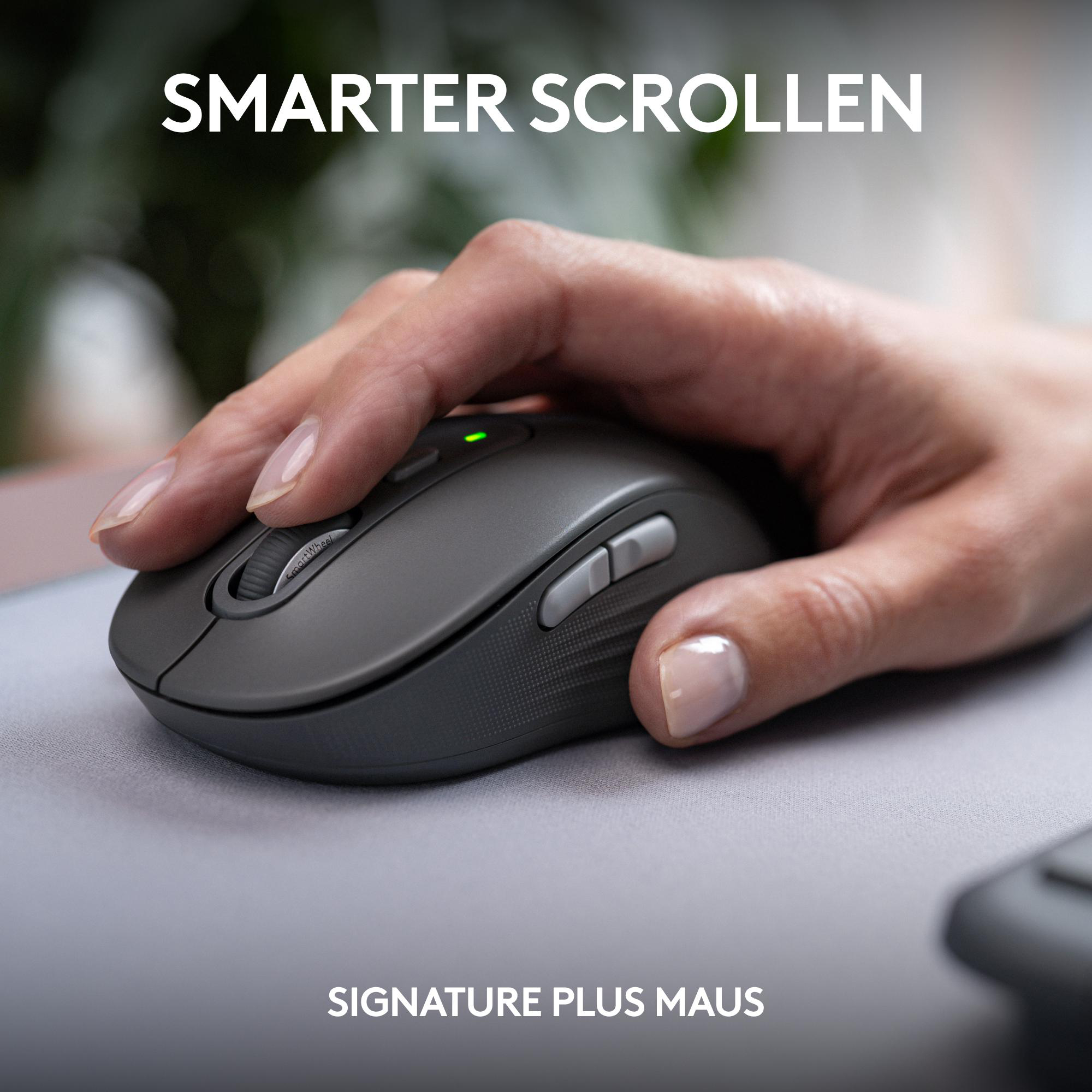 Eine Frau arbeitet an einem Schreibtisch. Ein Computer, ein Laptop und Papierflieger sind zu sehen.