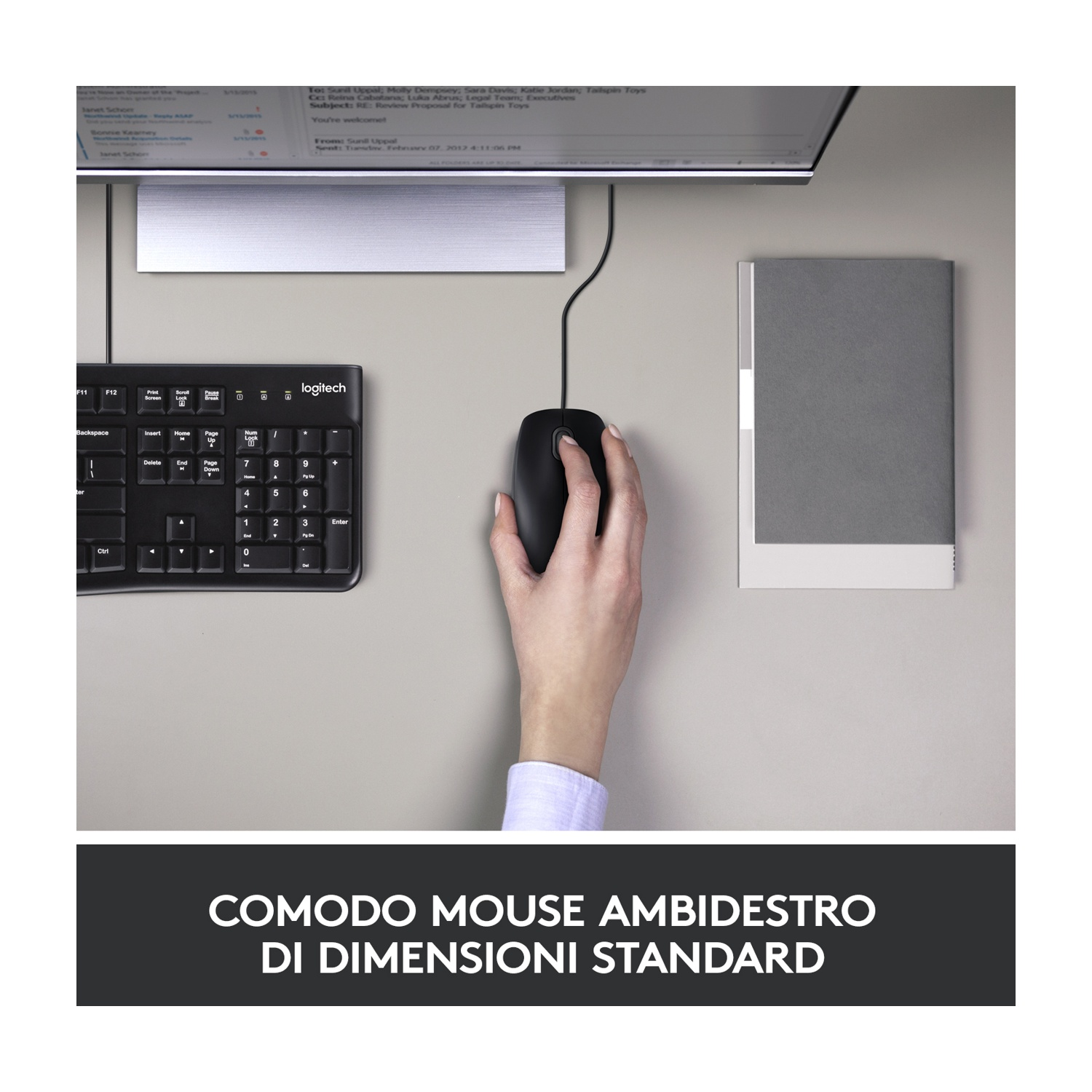 Mano che usa un mouse nero accanto a una tastiera e un quaderno.