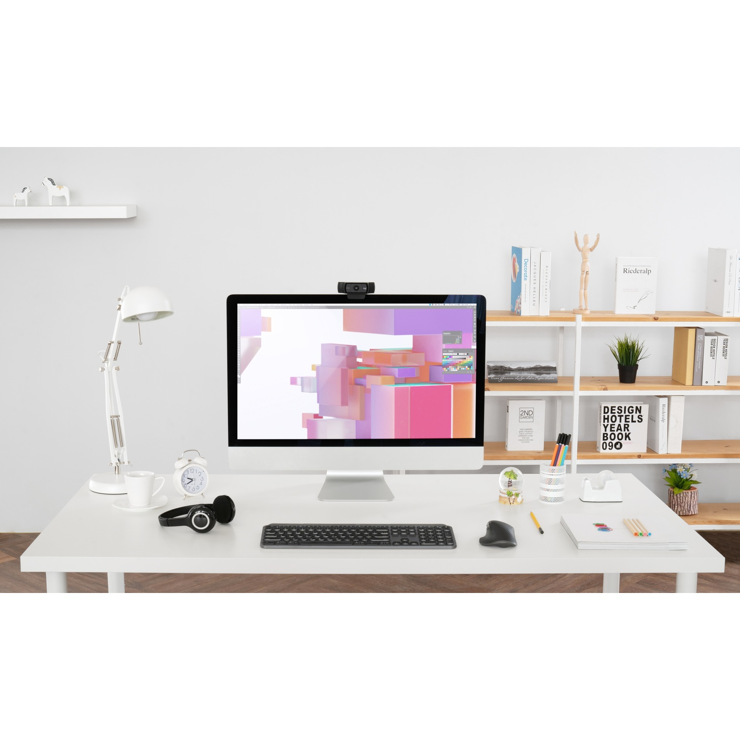 Una scrivania con un computer, un monitor e vari materiali per ufficio. Pulita e ben organizzata.