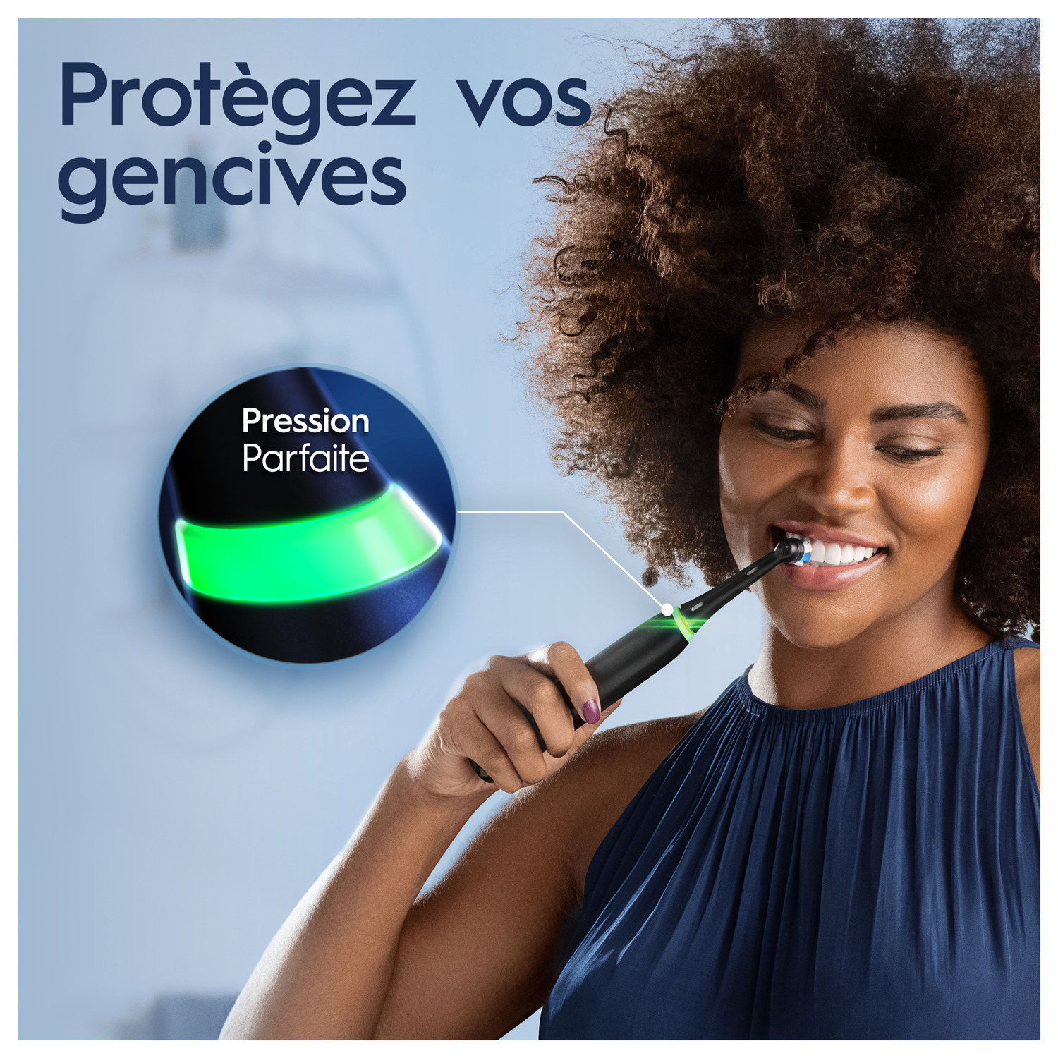 Une femme utilise une brosse à dents électrique, avec une lumière verte sur la brosse.