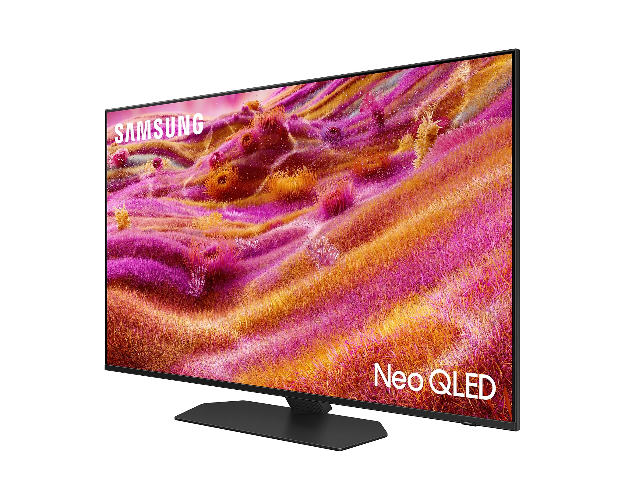 Egy Samsung TV fekete állvánnyal. A képernyő rózsaszín és sárga absztrakt tájat mutat.