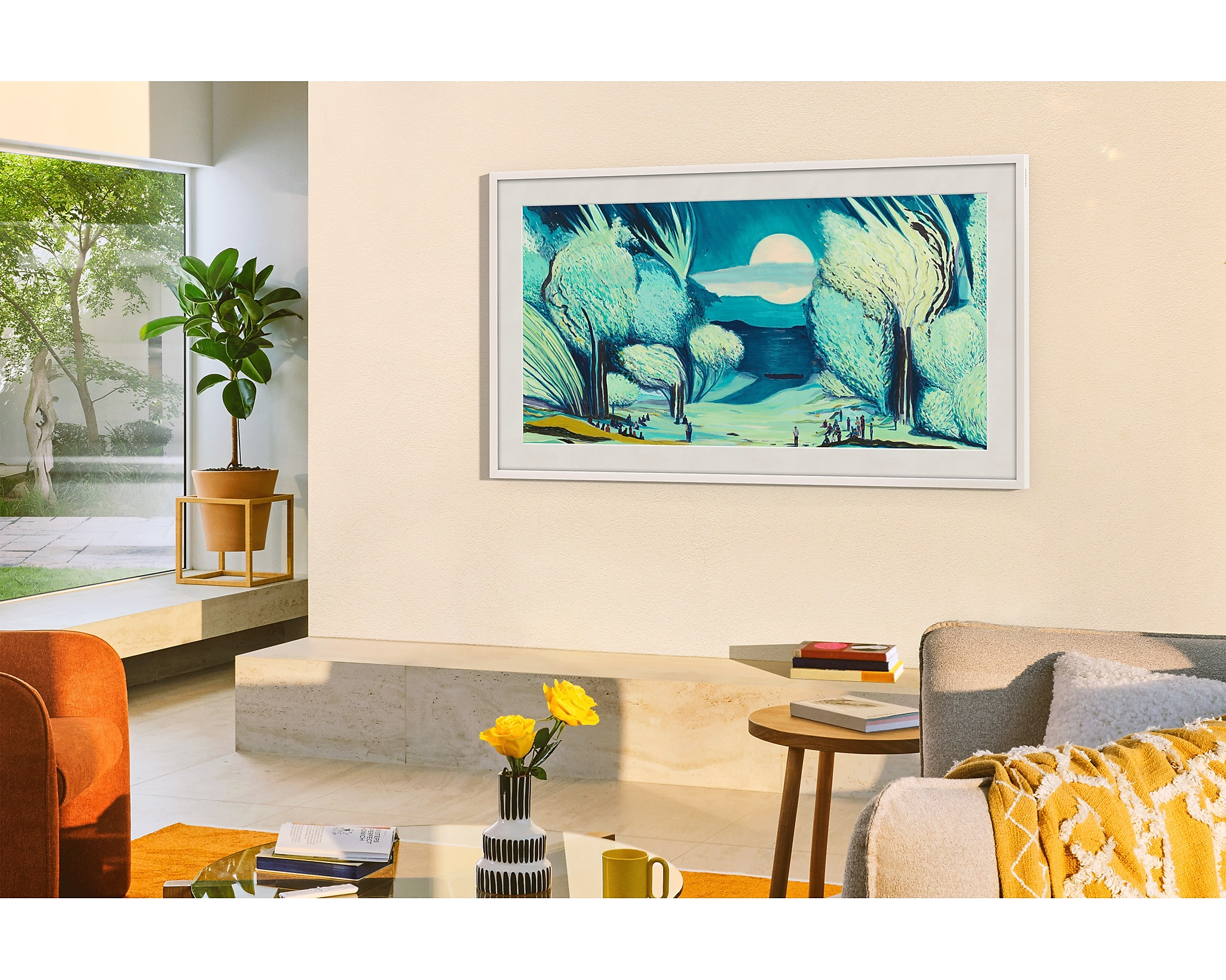 Egy TV a falon műalkotásokkal, egy növénnyel és egyéb dekorációs elemekkel.