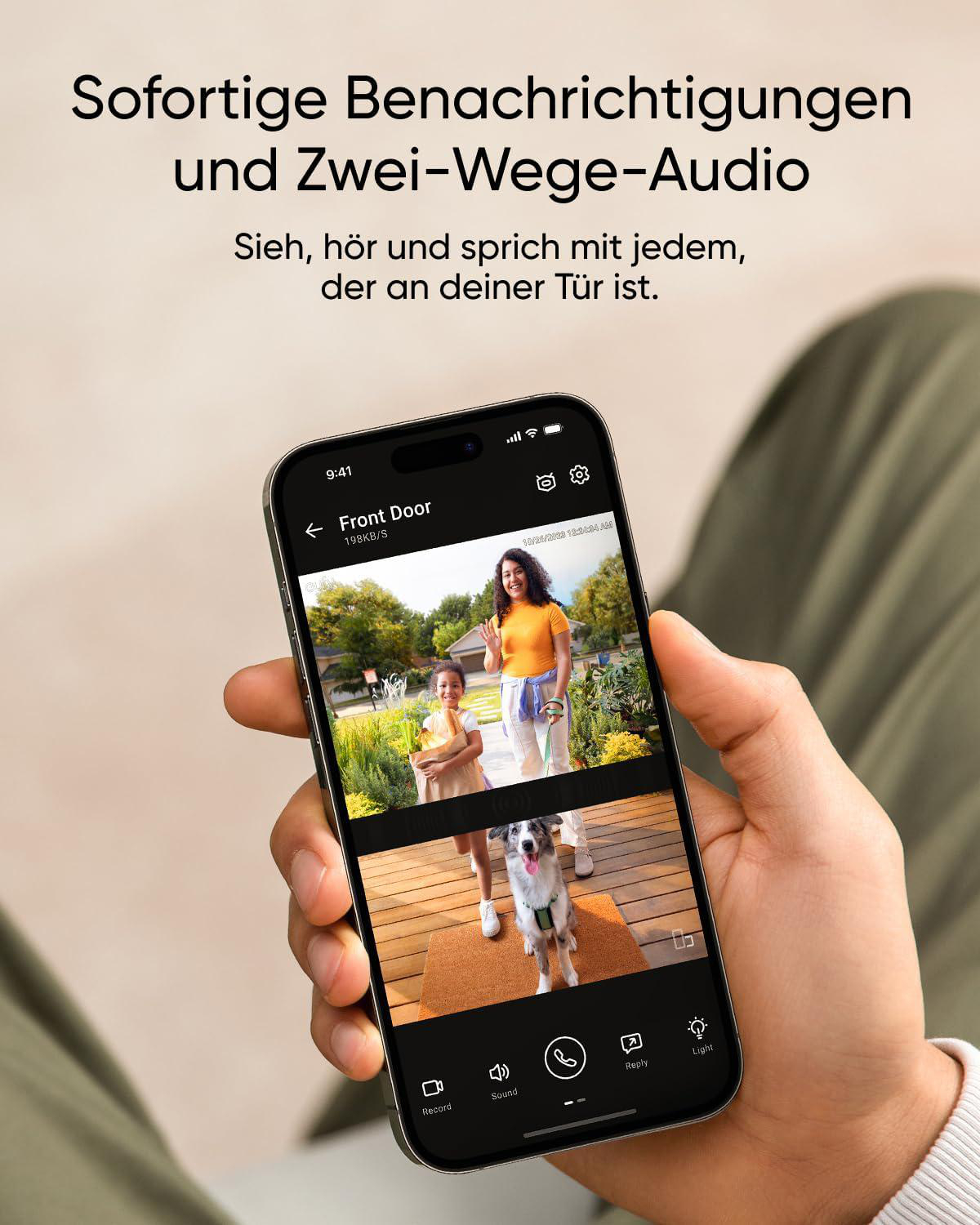 Eine Hand hält ein Telefon, auf dem ein Video einer Frau, eines Kindes und eines Hundes an einer Haustür angezeigt wird. Das Telefon hat auch Steuertasten.